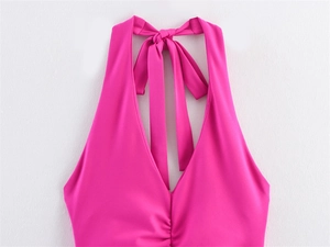 Detail of rose red halter neck dress featuring deep V-neck and ruffled bust design