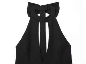 Dettaglio dell'abito nero con scollo all'americana, grande fiocco sul retro e scollo a V