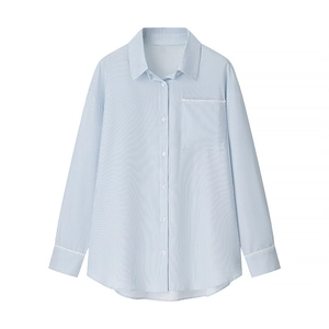 Detail of light blue striped shirt featuring white lace trim on cuffs and front pocket