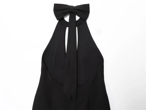 Dettaglio di un elegante abito nero all'americana con fiocco grande e scollatura cut-out