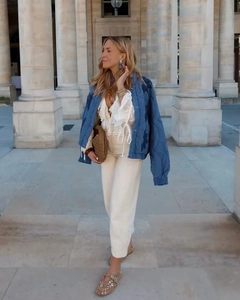Détail de la veste matelassée bleue avec chemise en dentelle et pochette en cuir