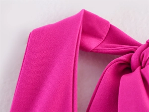 Close-up of the elegant fuchsia knot detail and premium knit fabric on a slim dress