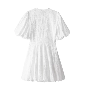 Detail of white mini dress featuring 3D floral jacquard fabric and puff sleeve back view
