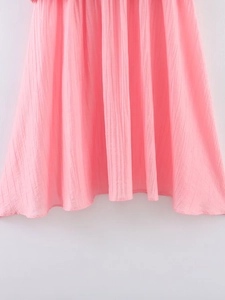Vue détaillée du tissu en maille plissé rose montrant la texture verticale et la finition