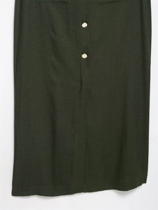 Detailed view of the olive green cotton linen fabric texture and vintage gold buttons