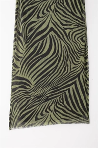 Detail of sheer zebra print mesh fabric in black and green for summer dress