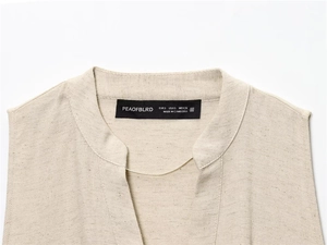 Detailed close-up of oatmeal linen dress neckline with stand collar and V-neckline