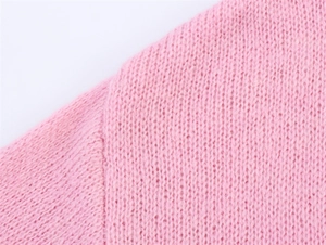 Detail der rosa Strickjacke mit Fokus auf hochwertige Schulternaht und feines Maschenbild