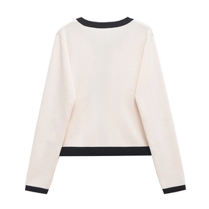 Vue détaillée du dos d'un cardigan en maille crème avec bordures contrastées noires