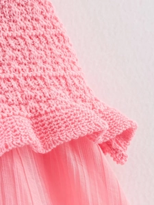 Détail de maille rose épaisse cousue avec du tissu en mousseline plissée pour femmes