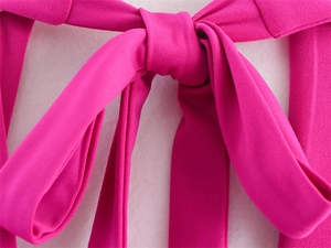 Detail of elegant magenta bow tie on a slim fit dress with smooth fabric texture