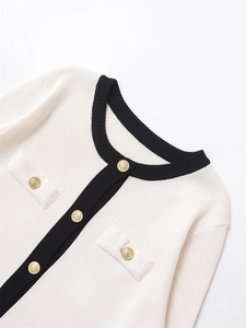 Détail du cardigan en maille avec texture côtelée et bouton doré embossé élégant