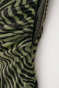 Detail of green and black zebra print mesh dress featuring ruching and invisible zipper