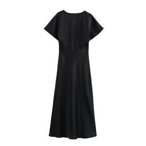 Détail de la texture du tissu en satin noir et de la manche plissée sur la robe midi