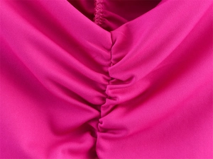 Close-up of magenta fabric featuring elegant ruched stitching and smooth texture