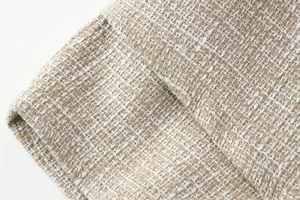 Vista macro del tessuto in tweed beige con fibre intrecciate e dettaglio della qualità del materiale
