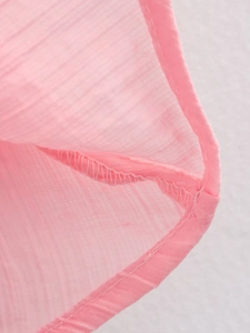 Détail macro du tricot rose montrant des rayures verticales et une finition de bordure