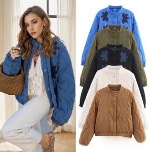 Détail de la broderie florale sur veste matelassée d'hiver avec poignets élastiques