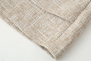 Vista dettagliata del tessuto in tweed beige con fili metallici dorati e trama intrecciata