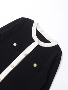 Détail d'un cardigan tricoté pour femme avec boutons dorés et bordures blanches