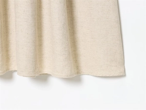 Macro view of the slim beige dress hem showing high-quality cotton linen fabric texture