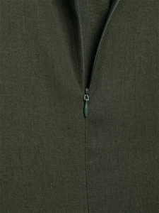 Detailed view of high-quality invisible zipper on textured dark olive green fabric