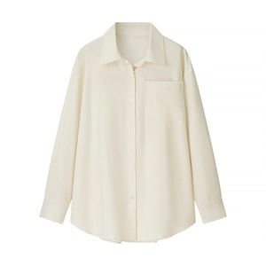 Detailed view of beige corduroy shirt featuring elegant lace-edged pocket and sleeve cuffs