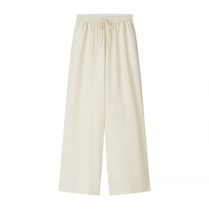 Detail of cream high-waisted wide-leg trousers with elastic drawstring waistband and fluid drape