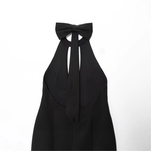 Elegante abito nero senza schienale con scollo a cavezza e un grande fiocco decorativo