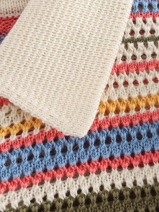 Detail of colorful crochet knit fabric with hollow-out pattern and striped texture