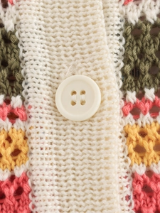 Macro view of multi-color crochet knit polo texture with a cream resin button detail