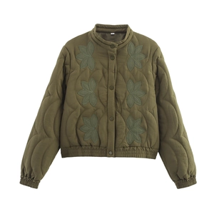 Détail d'une veste matelassée vert olive avec broderie florale et col montant