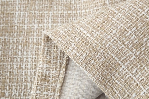 Dettaglio macro del tessuto tweed beige con fili dorati e trama strutturata