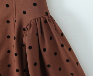 Détail du tissu beige à pois noirs avec fronces élégantes et texture sergé de qualité