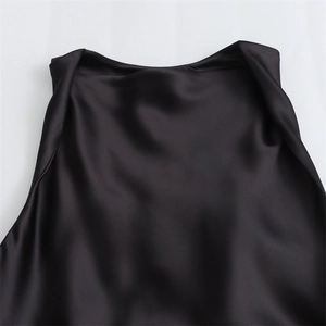 Detail view of the sleek black satin neckline with a natural draped cowl design