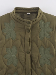 Détail d'une veste matelassée vert olive avec motifs floraux et boutons-pression