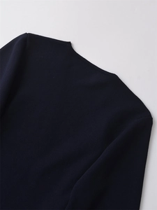 Detail of navy blue knit top showing fine texture and seamless stitching on the back shoulder