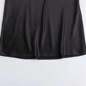 Detail of the smooth black satin dress hem showing refined stitching and silky texture