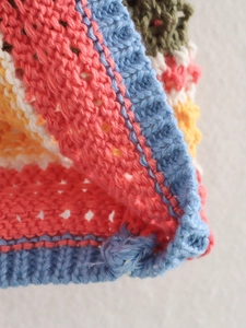 Detailed close-up of colorful crochet knit fabric with vibrant striped hollow-out texture
