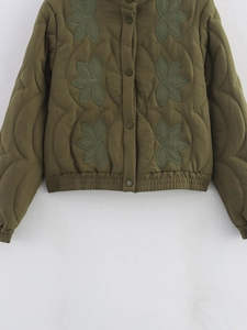 Détail de veste matelassée vert armée avec broderie de feuilles et boutons-pression