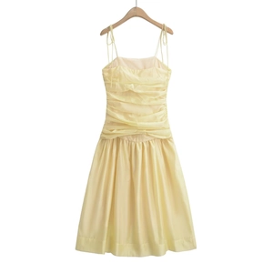 Detail of light yellow midi dress featuring ruched bodice and adjustable tie straps