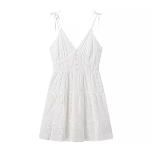 Close-up of white V-neck strap dress with eyelet embroidery and tiered ruffle skirt