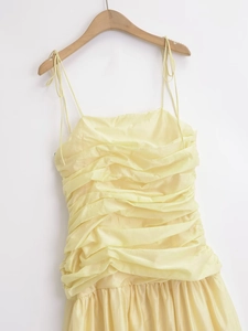 Pale yellow pleated summer midi dress with thin spaghetti straps and a ruched bodice
