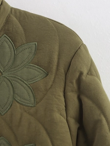 Détail de la veste matelassée vert olive avec broderie florale sur l'épaule