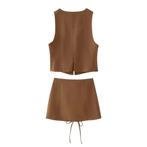 Détail de l'ensemble gilet et minijupe marron avec fente au dos et nœud sur le côté