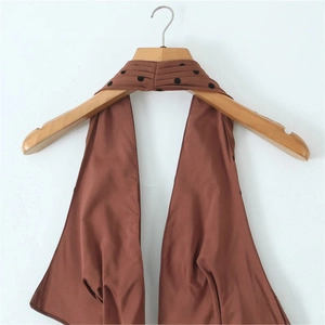 Robe dos nu marron avec décolleté en V profond et détails à pois noirs sur cintre en bois