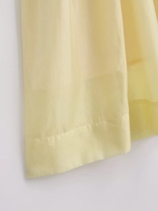 Detailed close-up showing the fine texture and hem stitching of the beige pleated midi dress