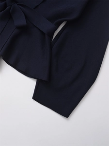 Detailed view of the dark navy knit fabric texture and waist belt design on the blazer