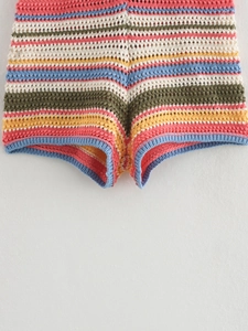 Macro detail of multi-color crochet knit shorts with striped pattern and blue hem edges