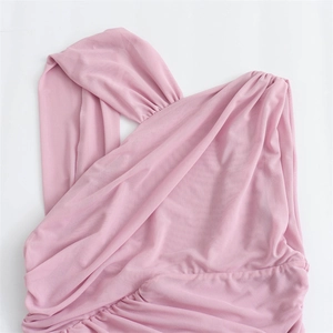 Detailed view of pink sheer fabric with intricate pleating and ruched design texture
